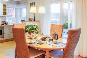 a kitchen with a wooden table with chairs and a dining room at Haubentaucher in Hemmenhofen