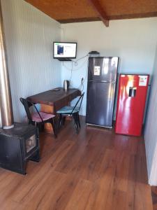 a dining room with a table and a refrigerator at Cabaña el Roble in Lago Ranco