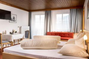 a hotel room with two beds and a dining room at Der Oswalderhof in Obertilliach