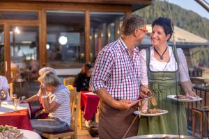 a man and a woman holding plates of food at Der Oswalderhof in Obertilliach +84 photos