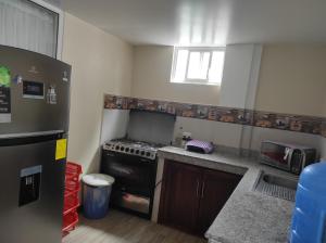 a small kitchen with a stove and a refrigerator at Casa vacacional in Baños