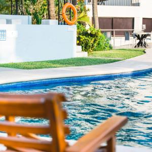 a pool with a bench and an orange life preserver at Hotel San Antonio in Tampico