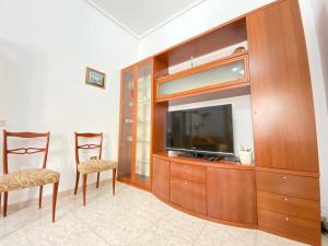 sala de estar con TV y 2 sillas en La casa di Palma, en Pachino