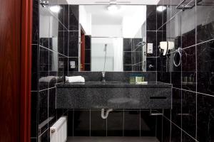 a black bathroom with a sink and a mirror at Hotel Bella Vista Warszawa in Warsaw +49 photos