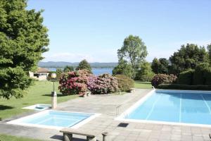una piscina in un cortile accanto a una casa di Oasi Lèsia - La Casa sul Lago con Spiaggia privata e piscina vista lago a Lesa