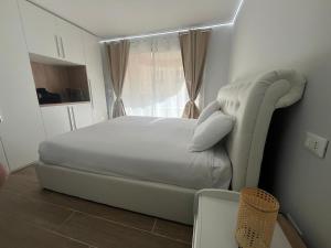 una camera da letto con un letto bianco e una sedia bianca di Appartamento Esclusivo in Monaco Palace Josephine a Beausoleil