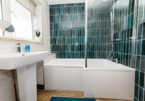 un bagno con vasca e lavandino di Ty Twt, A cottage by the sea a Tresaith Altre 32 foto