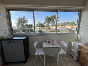 a kitchen with a table and chairs and a window at Les Fermettes in Saint-Jean-de-Monts