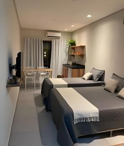 a bedroom with two beds and a dining room with a table at Manga Verde Milagres in São Miguel dos Milagres