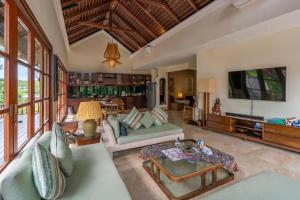 a living room with a couch and a tv at Boutique hotel villa Cantik and karma beach club in Uluwatu