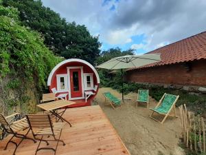 瓦尔斯罗德Wohnfass Fuchsbau的圆形房屋,配有椅子和桌子以及雨伞