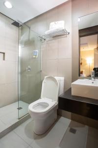 y baño con aseo, ducha y lavamanos. en Vieve Hotel, en Manila