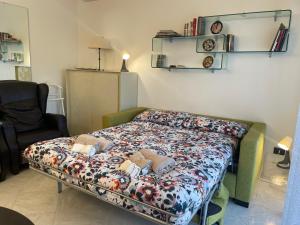 a bed in a room with a flowered bedspread at La Casa nel Parco by Smart-Home in Vallecrosia