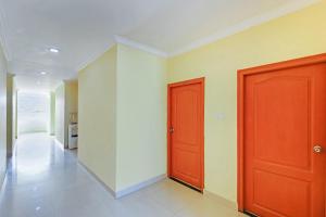 a hallway with two red doors in a room at Super Hotel O Golden Hive Madhapur Near Shilparamam in Hyderabad