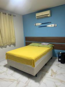a bedroom with a bed with a yellow bedspread at Privê estrela in Porto De Galinhas
