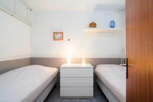 two beds in a small room with a white night stand at Ferienpark Sierksdorf App 382 - Strandlage in Sierksdorf