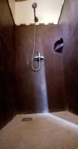 eine Dusche mit einem an der Wand befestigten Schlauch in der Unterkunft Kalahari Estate, Prestige & Quiet in Sali Poulang + 13 Fotos