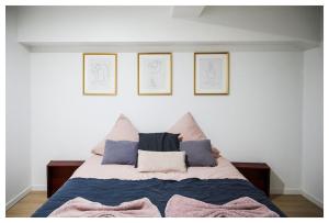 a bedroom with a bed with three drawings on the wall at Beau 3P à 20m du métro et 20 min du cœur de Paris in Les Lilas