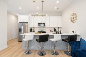 a kitchen with white cabinets and a island with bar stools at Gilean Urban Retreat in Chicago +31 photos