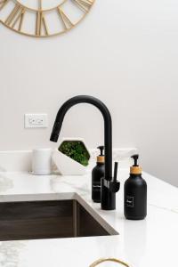 a kitchen sink with two black bottles on a counter at Gilean Urban Retreat in Chicago