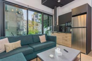 a living room with a blue couch and a kitchen at Amine Apart-Hotel by Stayinn in Beirut