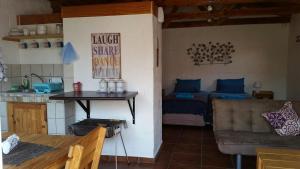 a kitchen and a living room with a table and a couch at Walvis Bay Backpackers & Self-catering in Walvis Bay