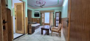 a bedroom with a bed and a table and a chair at MEHTA Guest House in Rāmpur