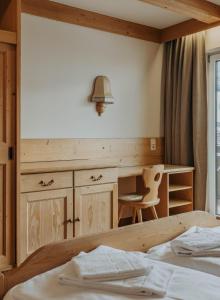 een slaapkamer met een bureau, een tafel en een bed bij Appartement Conrad in Saalbach Hinterglemm