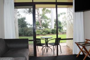 a living room with a patio with a table and chairs at Mt Tamborine Motel in Mount Tamborine