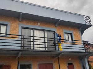 a woman standing on the balcony of a house at Studio cozy in Andoharanofotsy