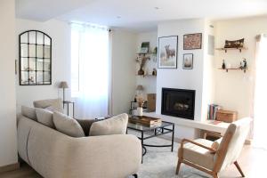 a living room with a couch and a fireplace at Maison Moz in Fontaines-en-Sologne