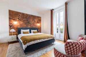 a bedroom with a large bed and a chair at Lidia by Terrys Homes in Le Cannet