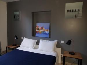 a bedroom with a large bed with white pillows at la Cigale in Collioure