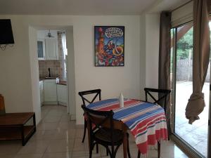 a dining room with a table and chairs and a kitchen at la Cigale in Collioure