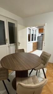 Un comedor con mesa y sillas de madera. en Modern City Apartment, en Bitola