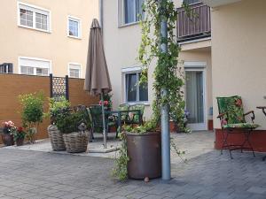 a patio with an umbrella and chairs and plants at Elisa Ferienwohnung in Wadern