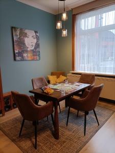 a dining room with a wooden table and chairs at Moodraz vakantiehuis centrum Peer in Peer
