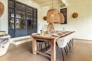 a dining room with a wooden table and chairs at Villa Leon Spacious Tropical Villa with pool and outdoor kitchen in Jan Thiel