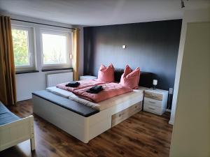 a bedroom with a large bed with pink pillows at Ferienhaus Montessori in Naundorf