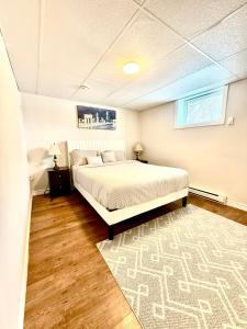 a bedroom with a bed and a rug at Cozy Comfort Stay Moncton - 2 Bedrooms with Kitchen and Parking in Moncton