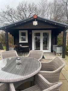 a table and chairs with a table and a house at The Lodge in Penrydd