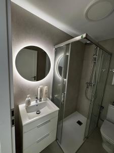 a bathroom with a sink and a shower with a mirror at Apartament PREMIUM in Torrevieja +11 photos