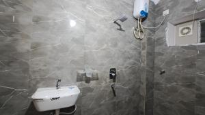 a bathroom with a sink and a shower at Jhanu's Home 1 in Gundipet +12 photos