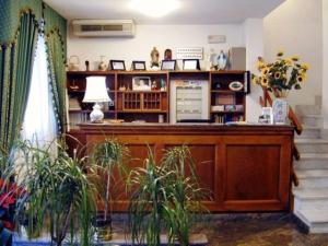 a room with a desk with a lamp and some plants at Hotel Astoria in Viareggio