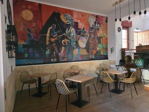ein Restaurant mit Tischen und Stühlen und einem großen Gemälde an der Wand in der Unterkunft THAT'S LOVE Fiumicino Jazz in Fiumicino