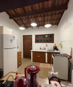 a kitchen with a white refrigerator and a stove at Linda casa com estilo buziana in Búzios