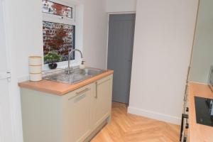 una cocina con fregadero y ventana en Entire home in Staffordshire, en Stafford 78 fotos más