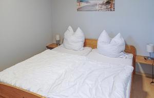 - un lit avec des draps et des oreillers blancs dans l'établissement Holiday Home Mölschower Weg Y, à Trassenheide 3 autres photos