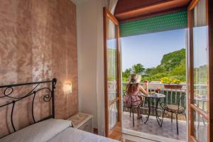 a woman sitting at a table on a balcony at Casa Ersilia in Agerola