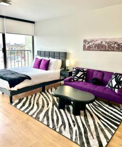 a bedroom with a bed and a purple couch at Salt City Loft in Salt Lake City